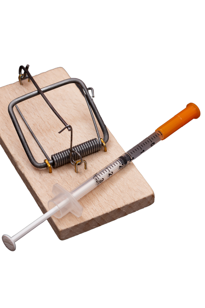 Syringe on a mousetrap, symbolizing the dangers and risks of opioid use.